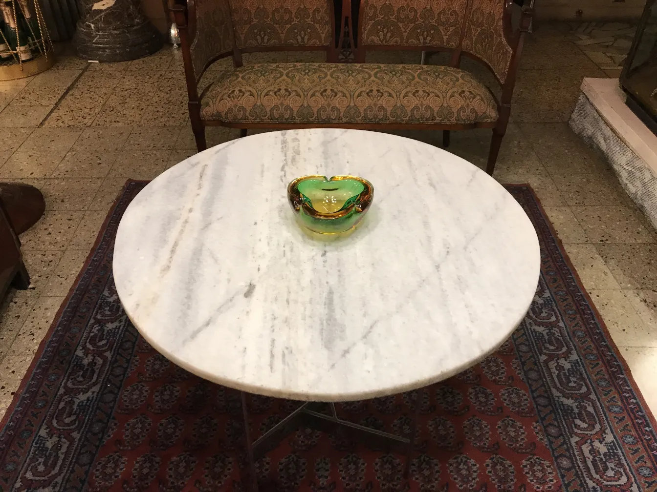 bonita peça de cristal de murano em verde e amarelo, com formas elegantes sobre uma mesa de mármore branco