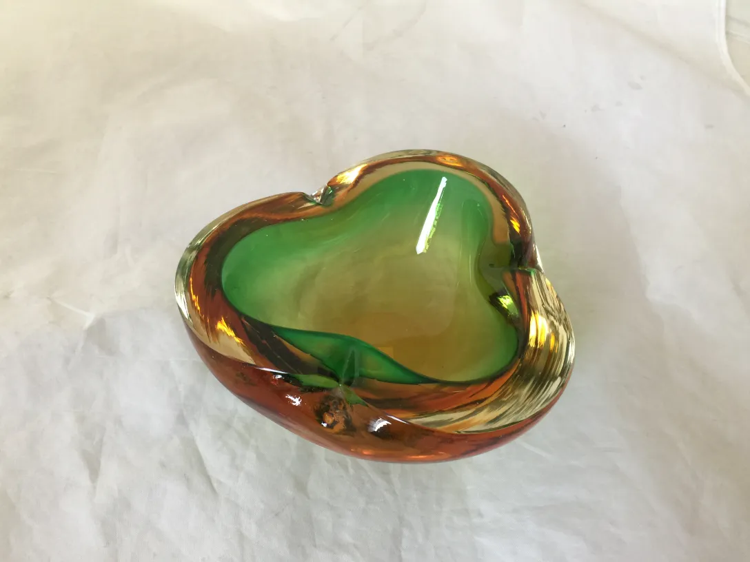 murano glass heart-shaped piece in green and amber colors