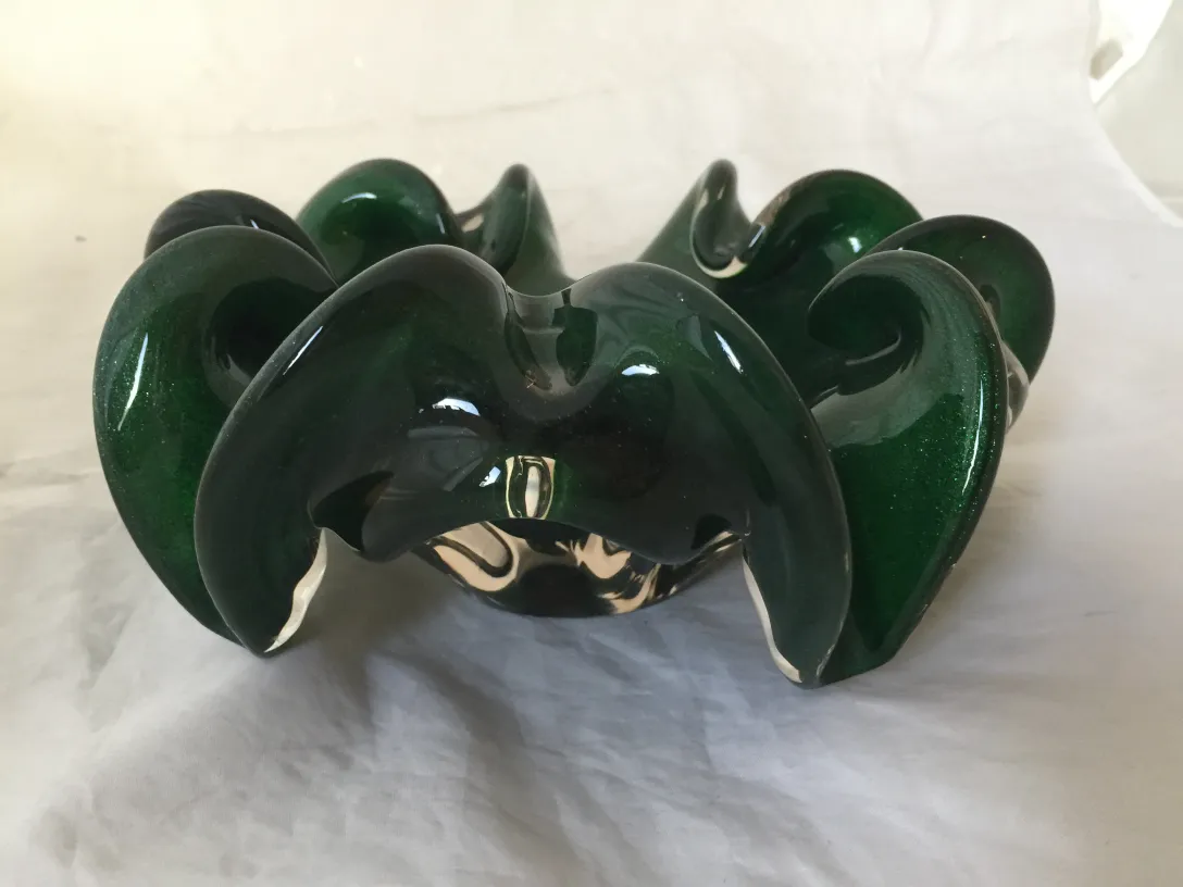 Schönes grünes Murano-Glas mit glatten Kanten und eleganten Formen, in einer antiken Umgebung.