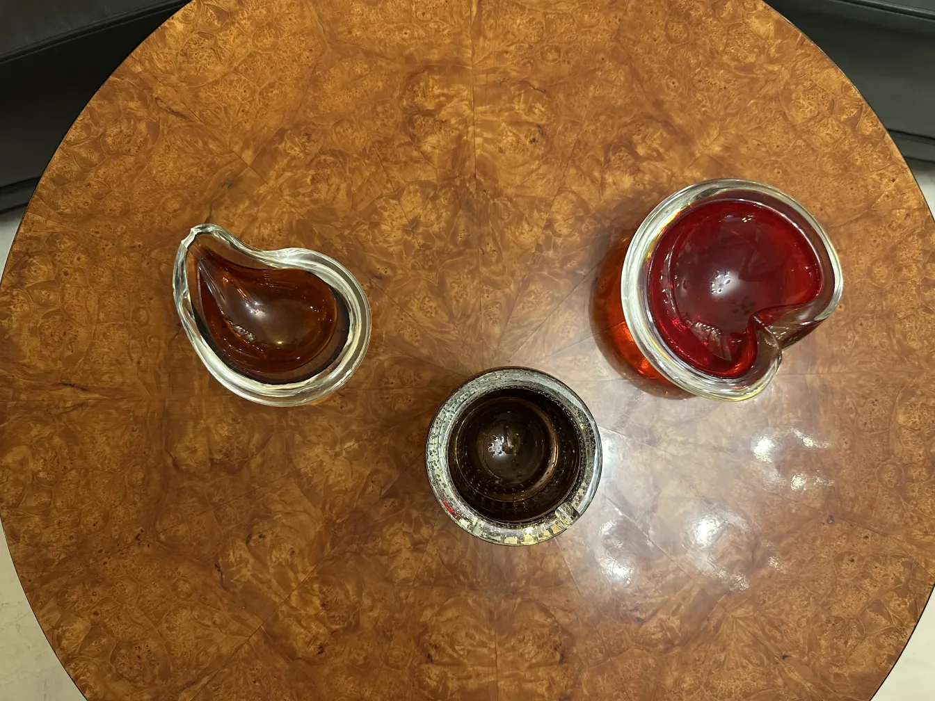 Tres piezas de cristal de Murano en una mesa de madera