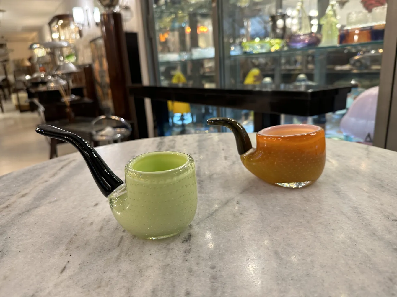 dos antiguas pipas de cristal de murano en colores suaves sobre una mesa