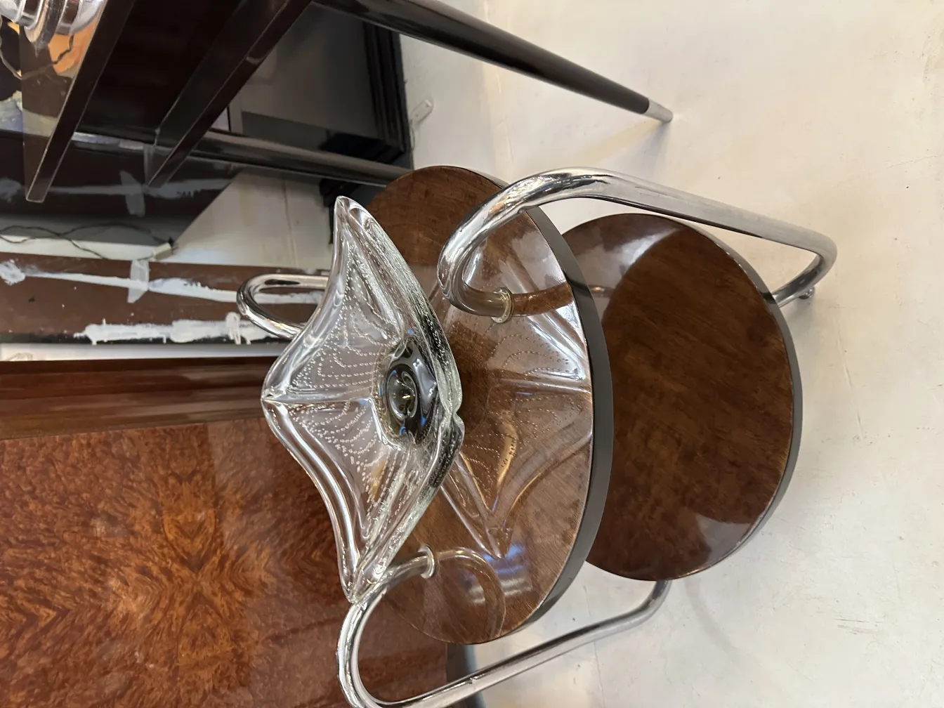 peça decorativa antiga de cristal de murano com forma elegante e brilho claro, colocada sobre uma mesa de madeira.