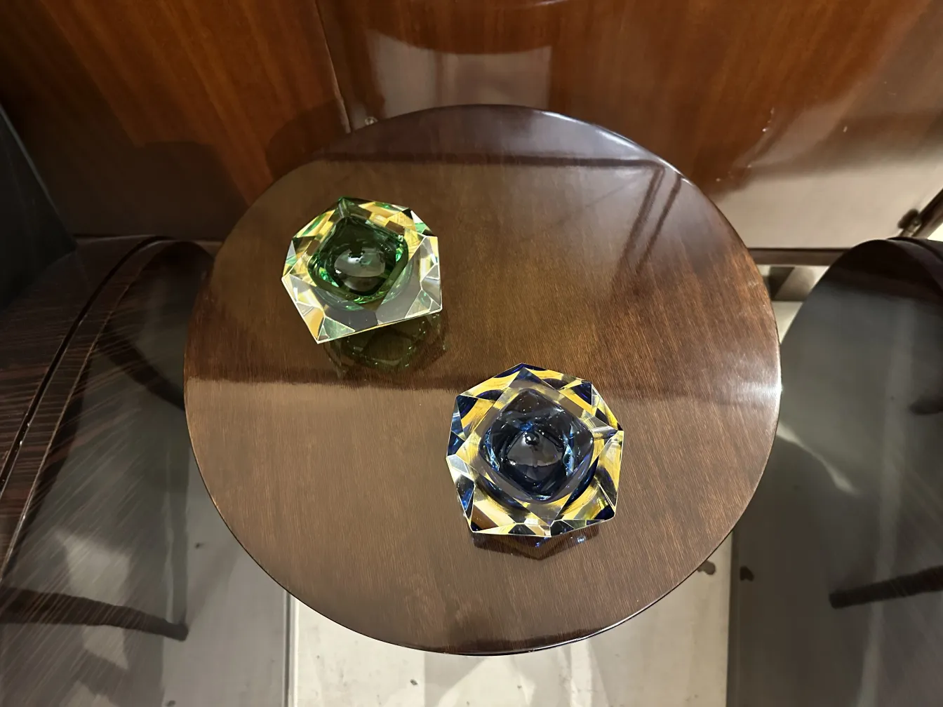 two pieces of Murano glass in green and blue on a table