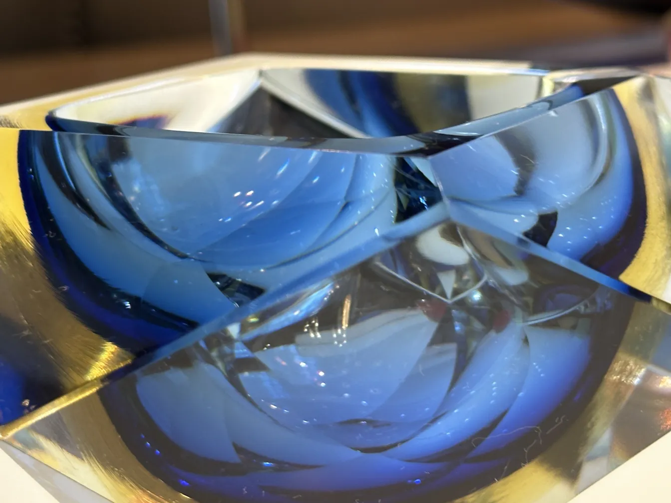 Cristal de Murano azul com formas angulares refletindo luz.