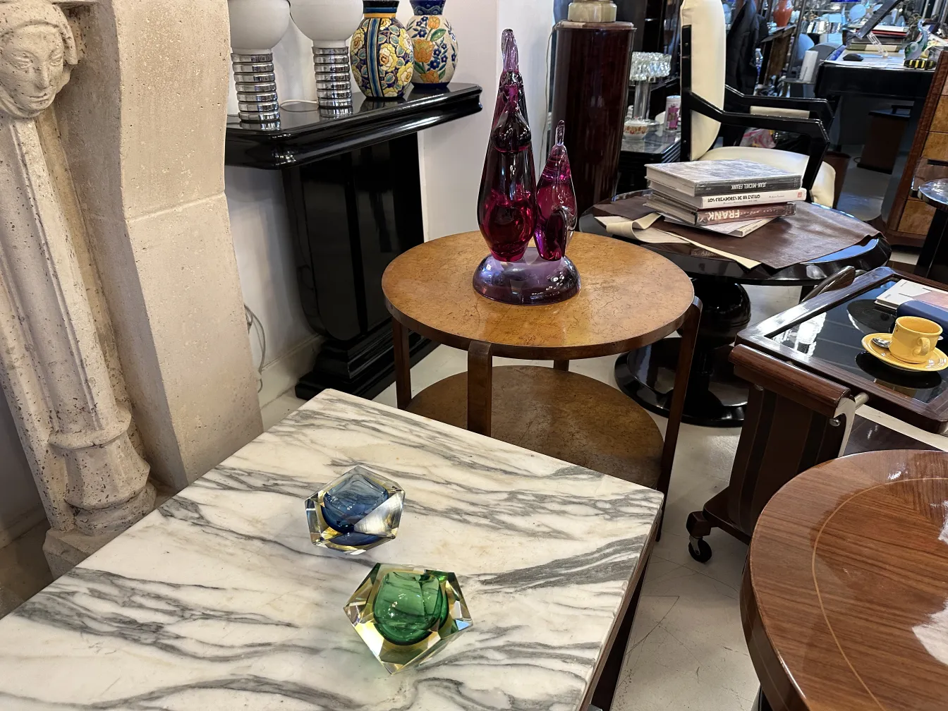 two murano glass sculptures in green and blue on a table