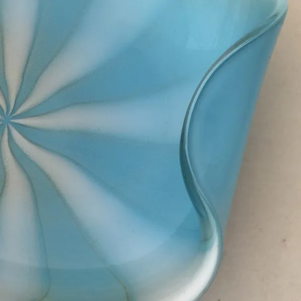 detail eines alten murano-glases in hellblau mit gewellter form und sanften mustern