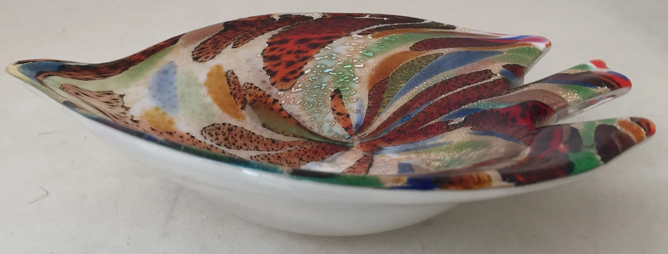 bowl de cristal de murano con colores vibrantes y patrones decorativos, colocado sobre una superficie clara