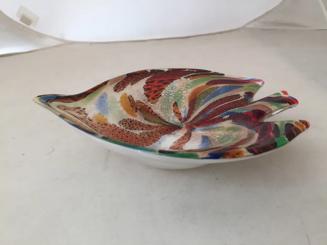 Figura antiga de cristal de Murano com cores vibrantes e formas elegantes em um ambiente neutro.