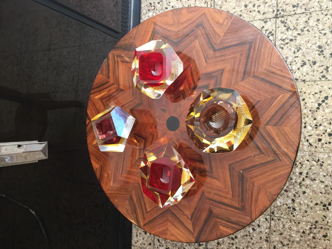 vier stücke murano-glas in rot und gold auf einem tisch