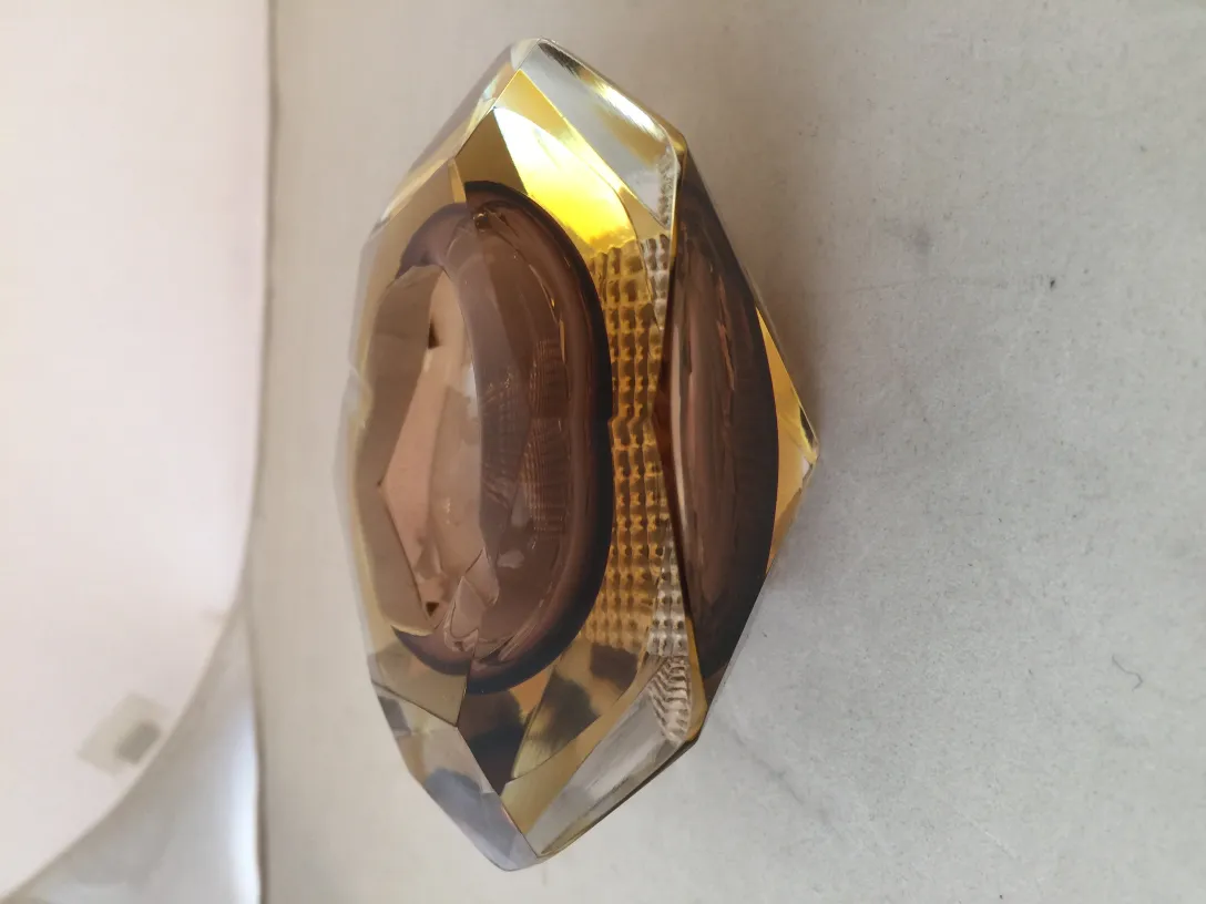 Antiguo cristal de Murano decorado en tonos dorados junto a un fondo suave.