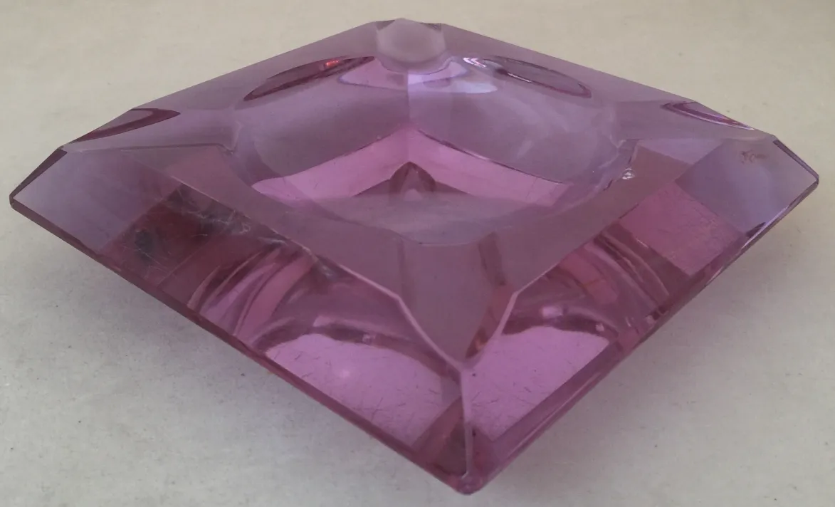 Cristal de Murano antigo com forma angular e cor rosada, ambiente elegante.