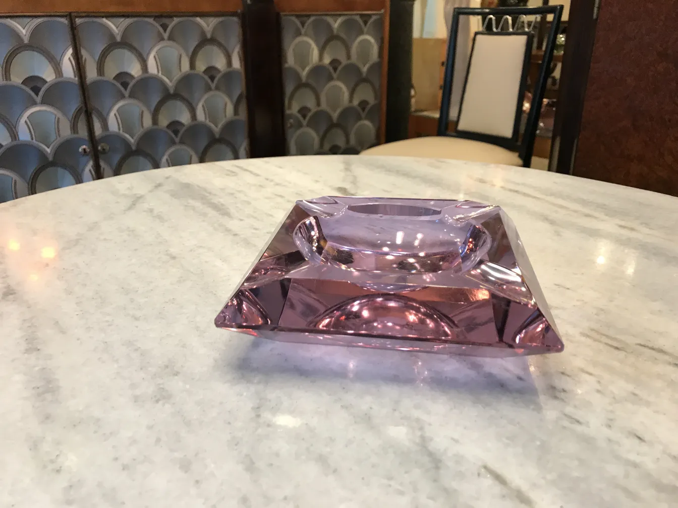 antique Murano glass ashtray, pink color, geometric shape, on marble table.