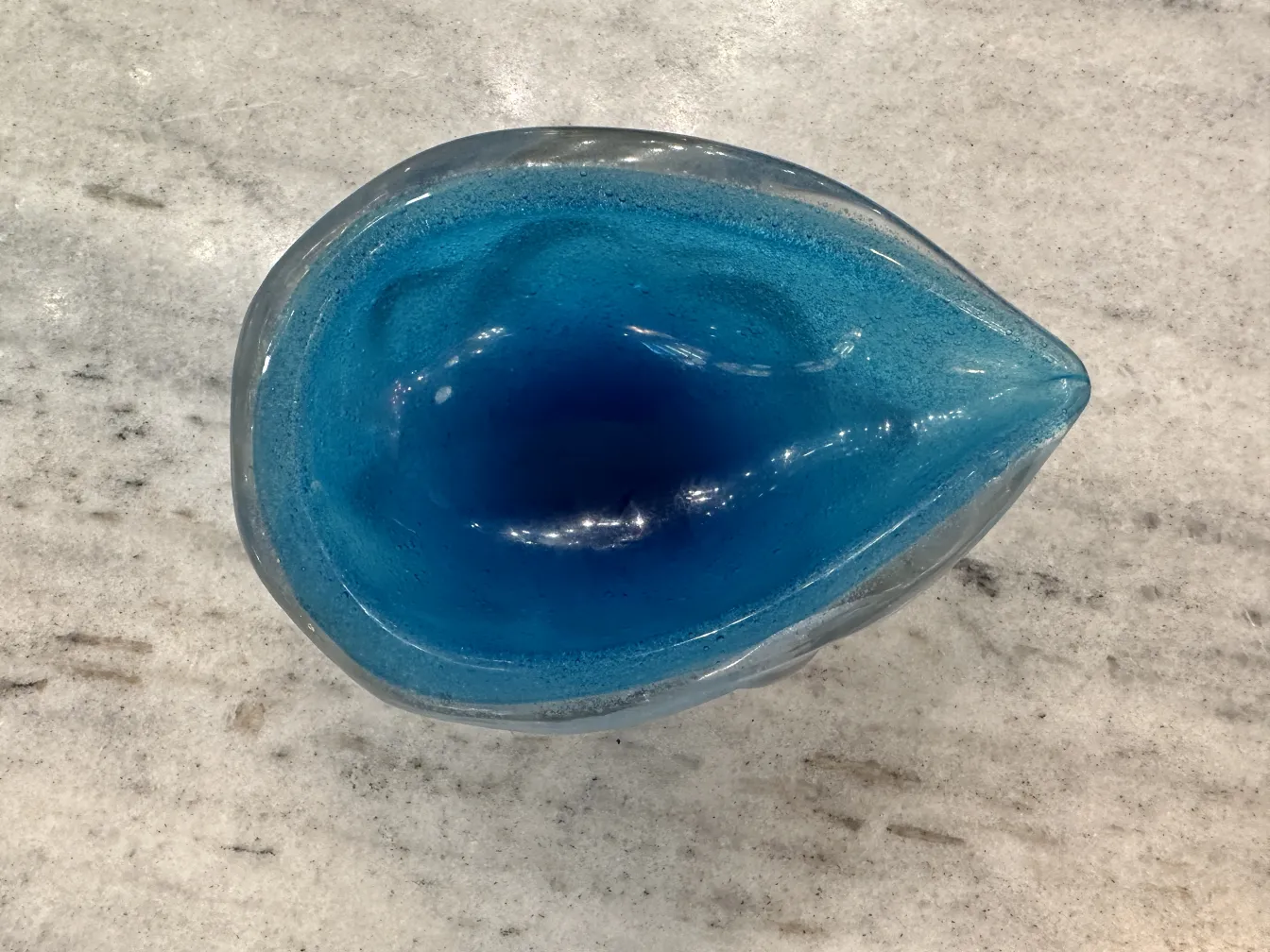 Antikes Murano-Glas in Blattform mit wunderschöner blauer Oberfläche auf hellem Hintergrund.