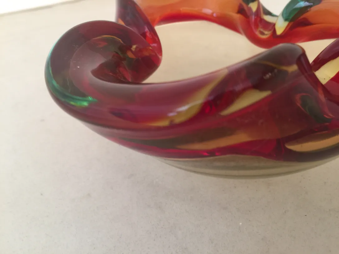Antique Murano glass with colorful red and green swirl patterns.