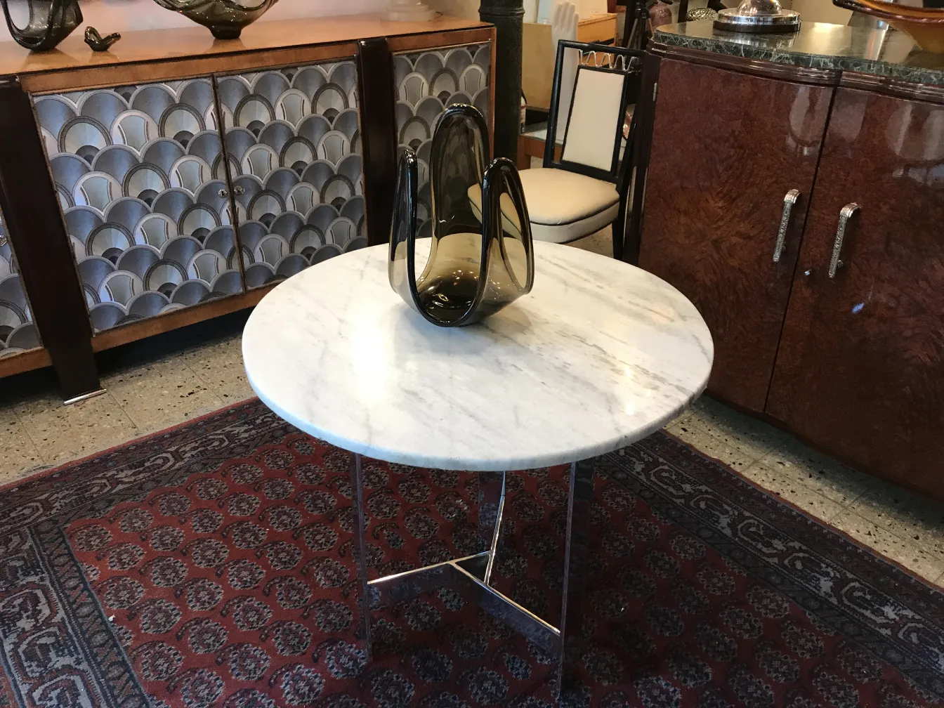 Cristal de Murano antigo em uma mesa redonda branca com decoração escura