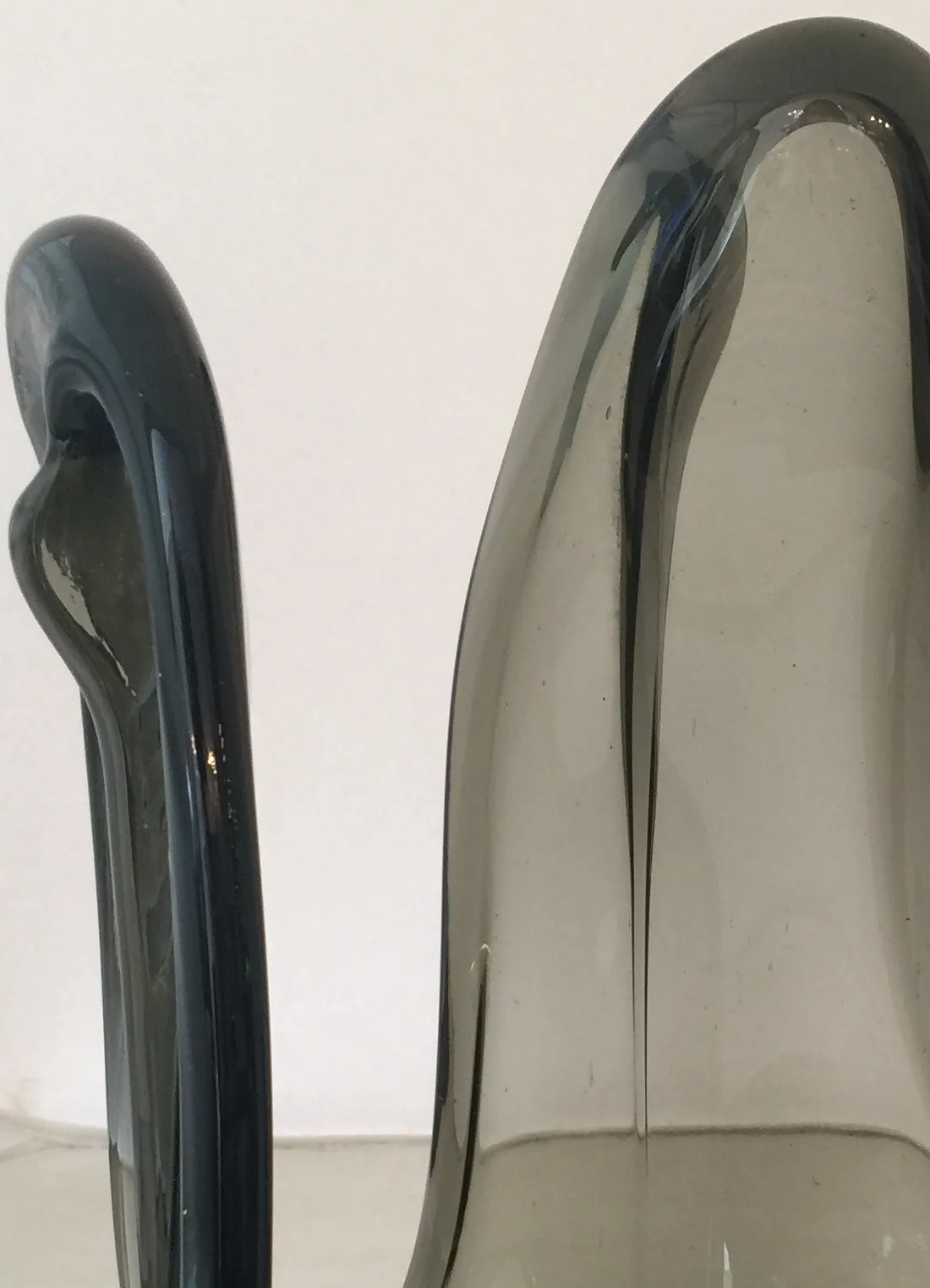 an antique murano glass jug in smoky gray with a curved design