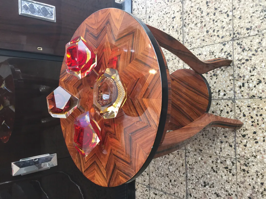 esfera e figuras de cristal de murano em tons de vermelho e âmbar sobre mesa elegante