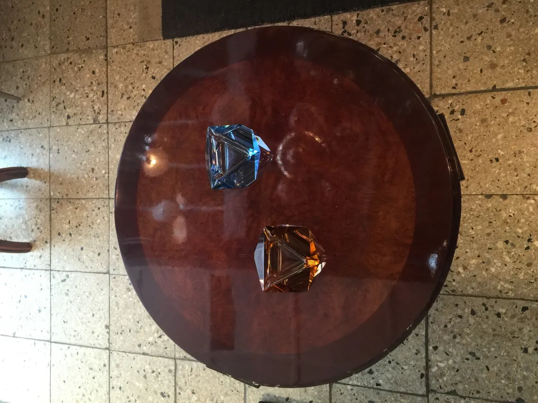 deux cristaux anciens en forme de diamant, bleu et ambre sur une table ronde