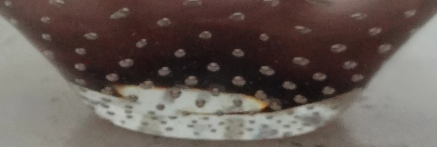 Cristal de Murano antigo com um padrão de pontos brancos, visão de perto.