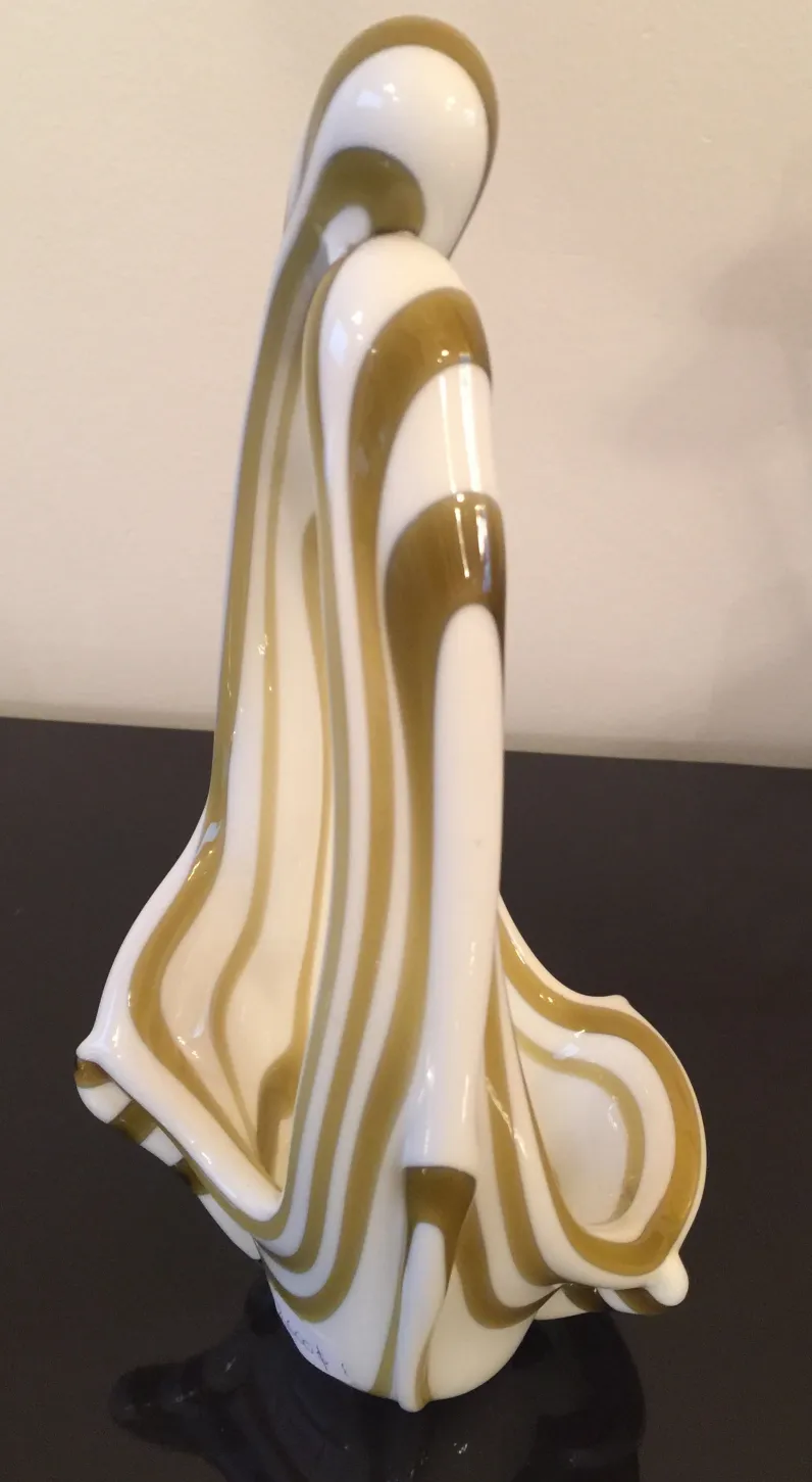 antike murano-glaskulptur, weiß-braun gestreift, vor dunklem hintergrund