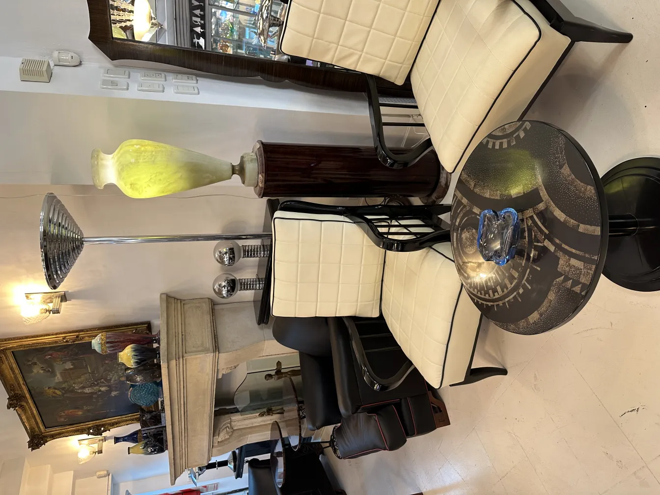 Blaues Murano-Glas auf schwarzem Tisch, umgeben von modernen Stühlen