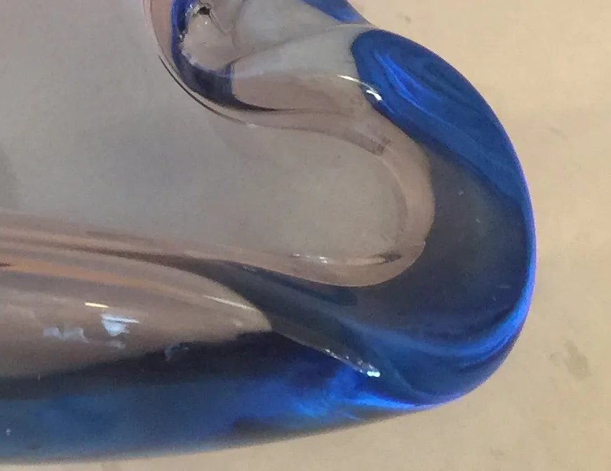 Ancien cristal de Murano avec une forme bleue brillante, présentation élégamment incurvée.