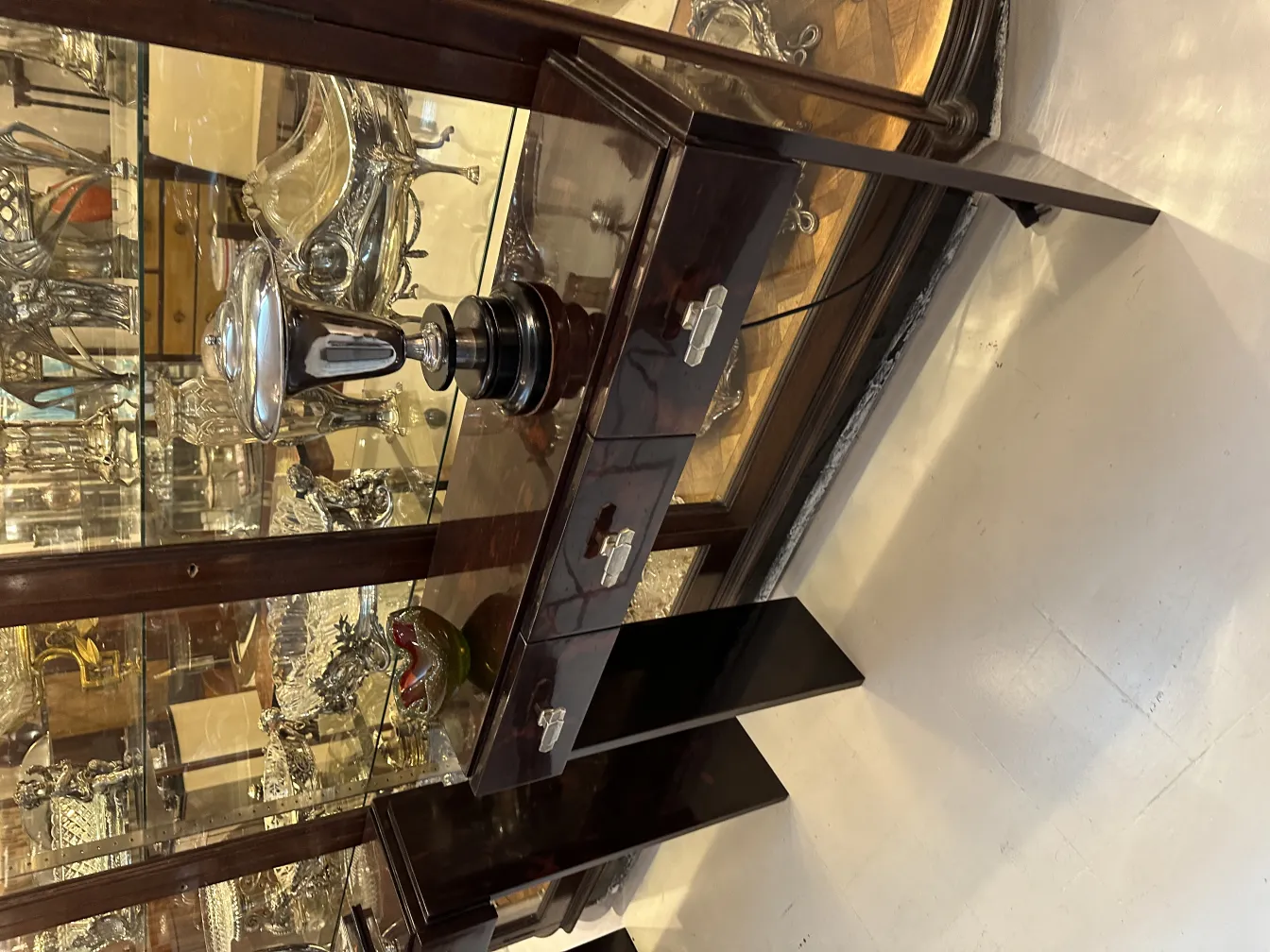 Antico vetro di Murano di forma rotonda, dettagli argentati e sfondo elegante con altre antichità.