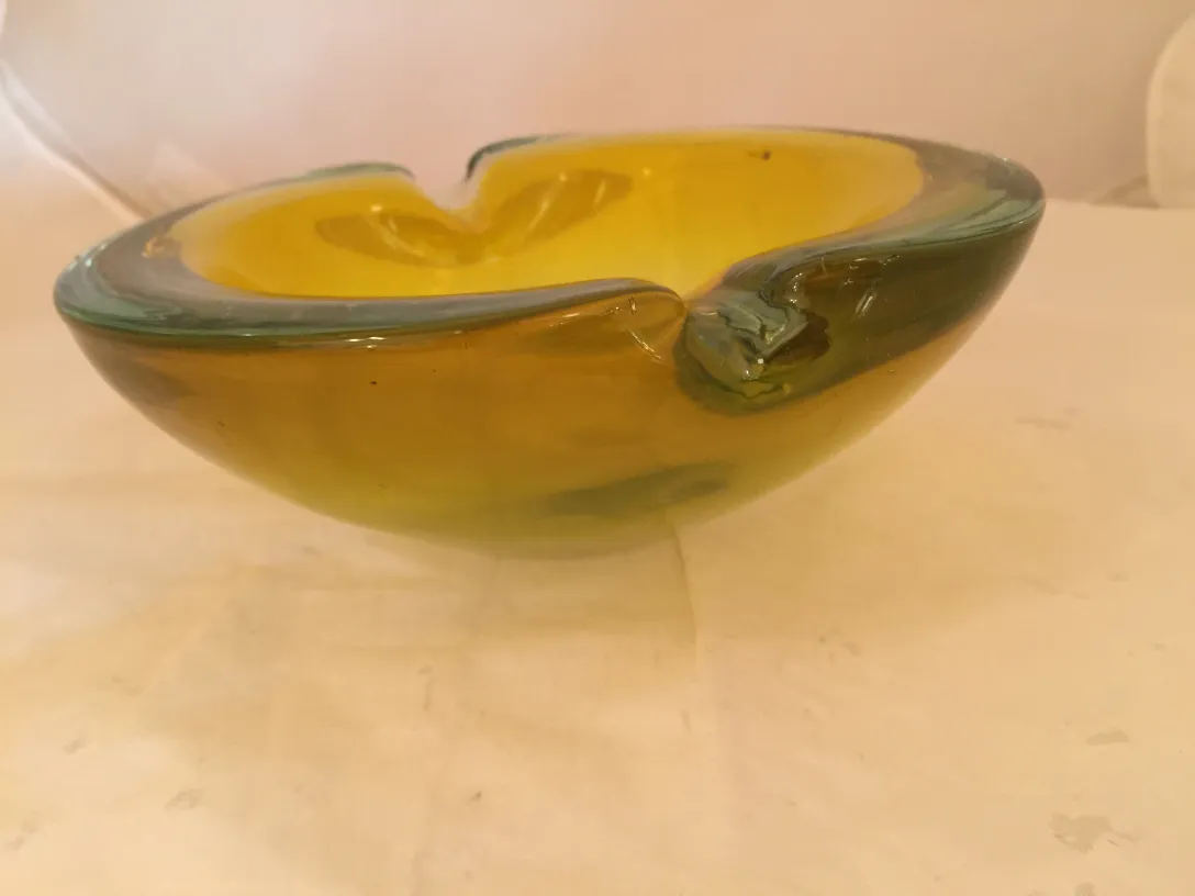 Cristallo di Murano decorativo in tonalità gialla con dettagli verdi in un ambiente neutro