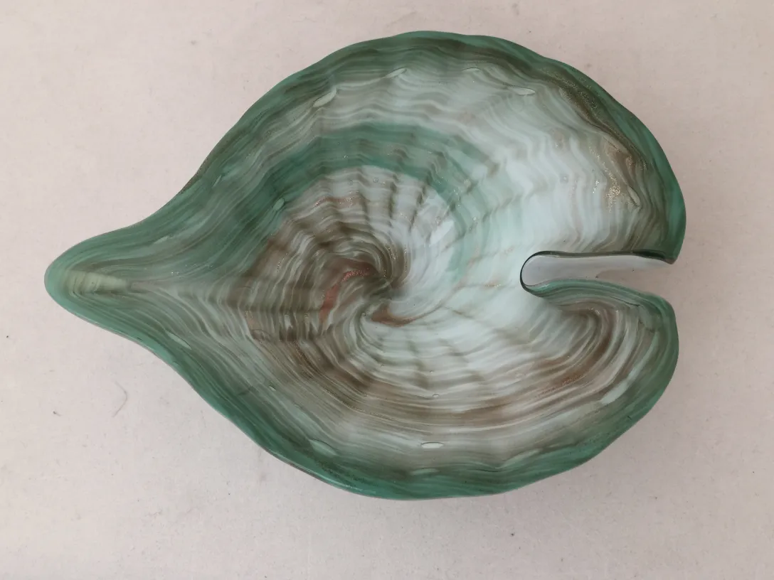 hermoso cristal de murano antiguo en forma de concha, colores verdes y blancos, fondo liso