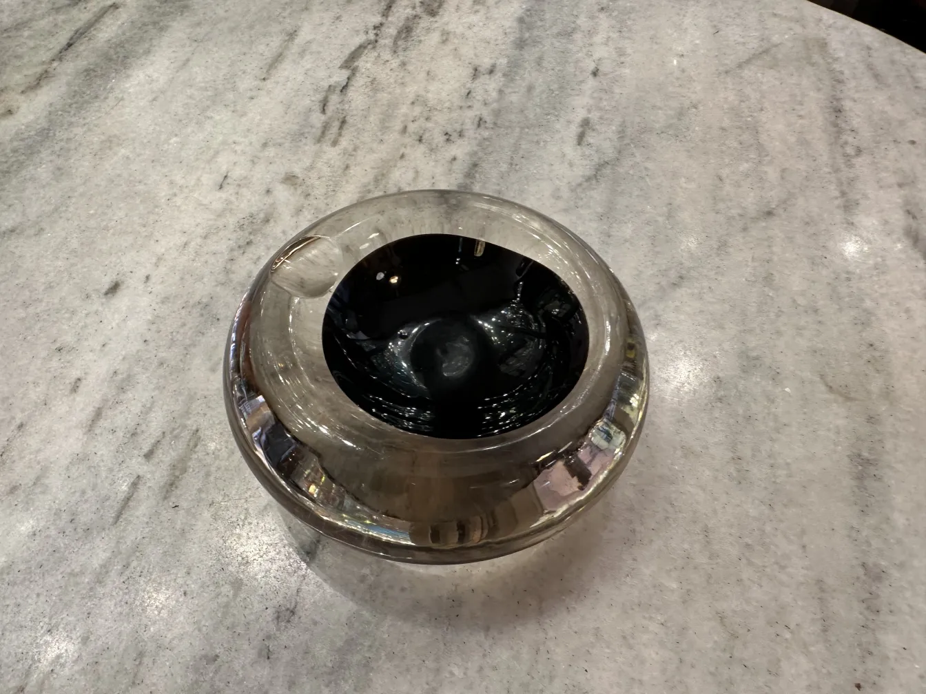 Antico vetro di Murano con un design nero, su una superficie chiara.