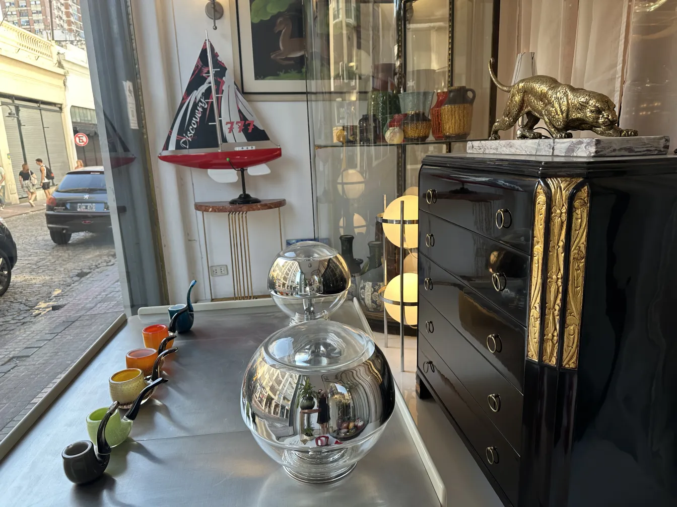 antike Murano-Glas-Kugel auf einem Tisch, umgeben von bunten Dekorationsgegenständen