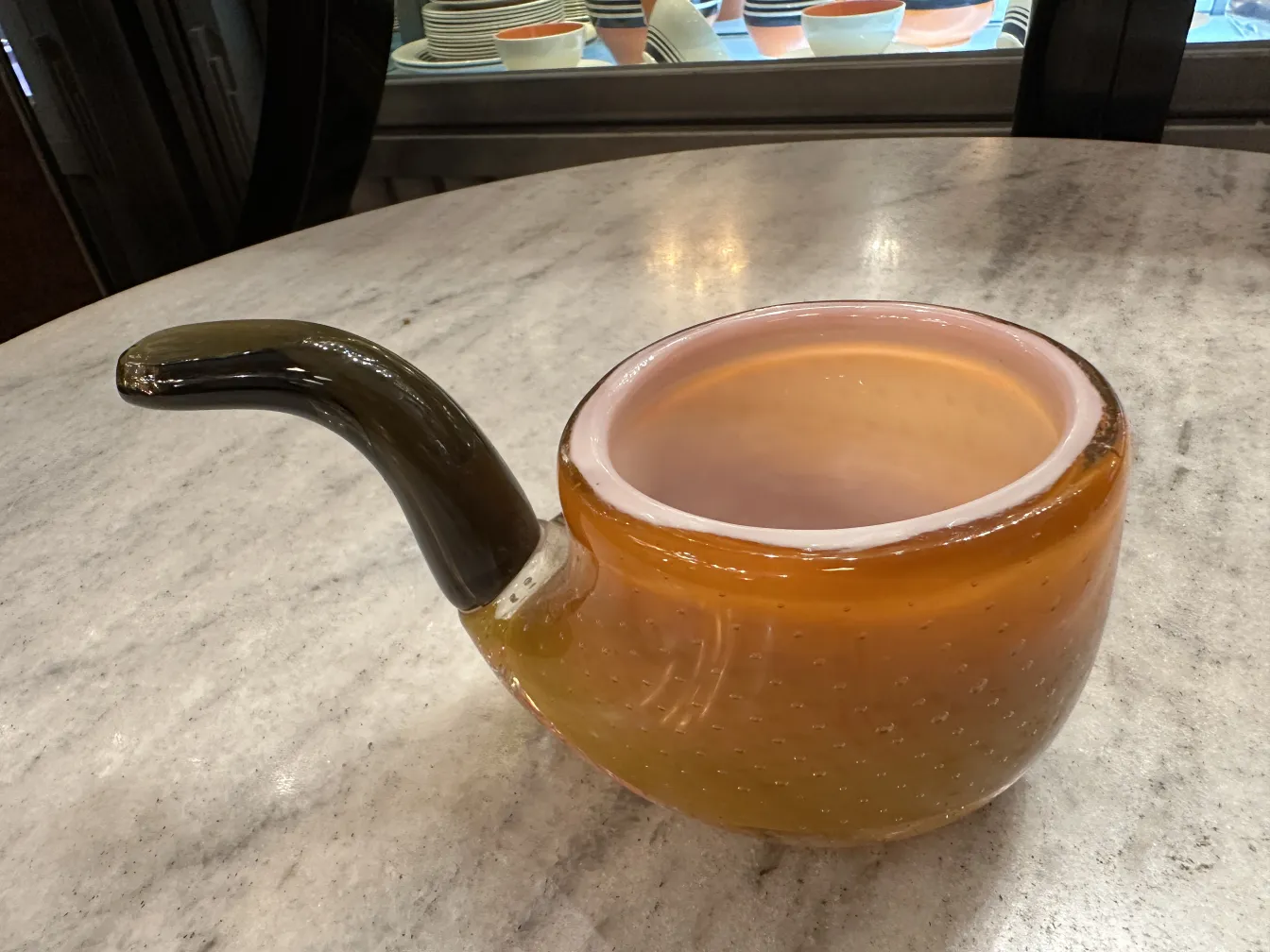 Античное муранское стекло янтарного цвета с изогнутым носиком и визуальными деталями.