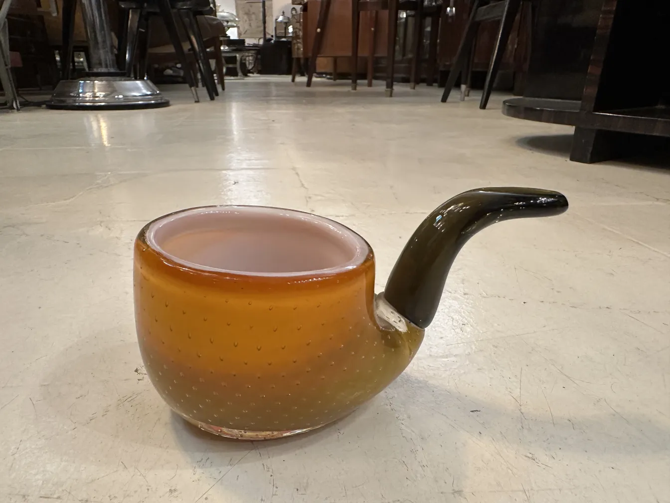 vetro di murano a forma di ciotola, colore ambra, decorato con un design sottile e una base elegante in un contesto antico