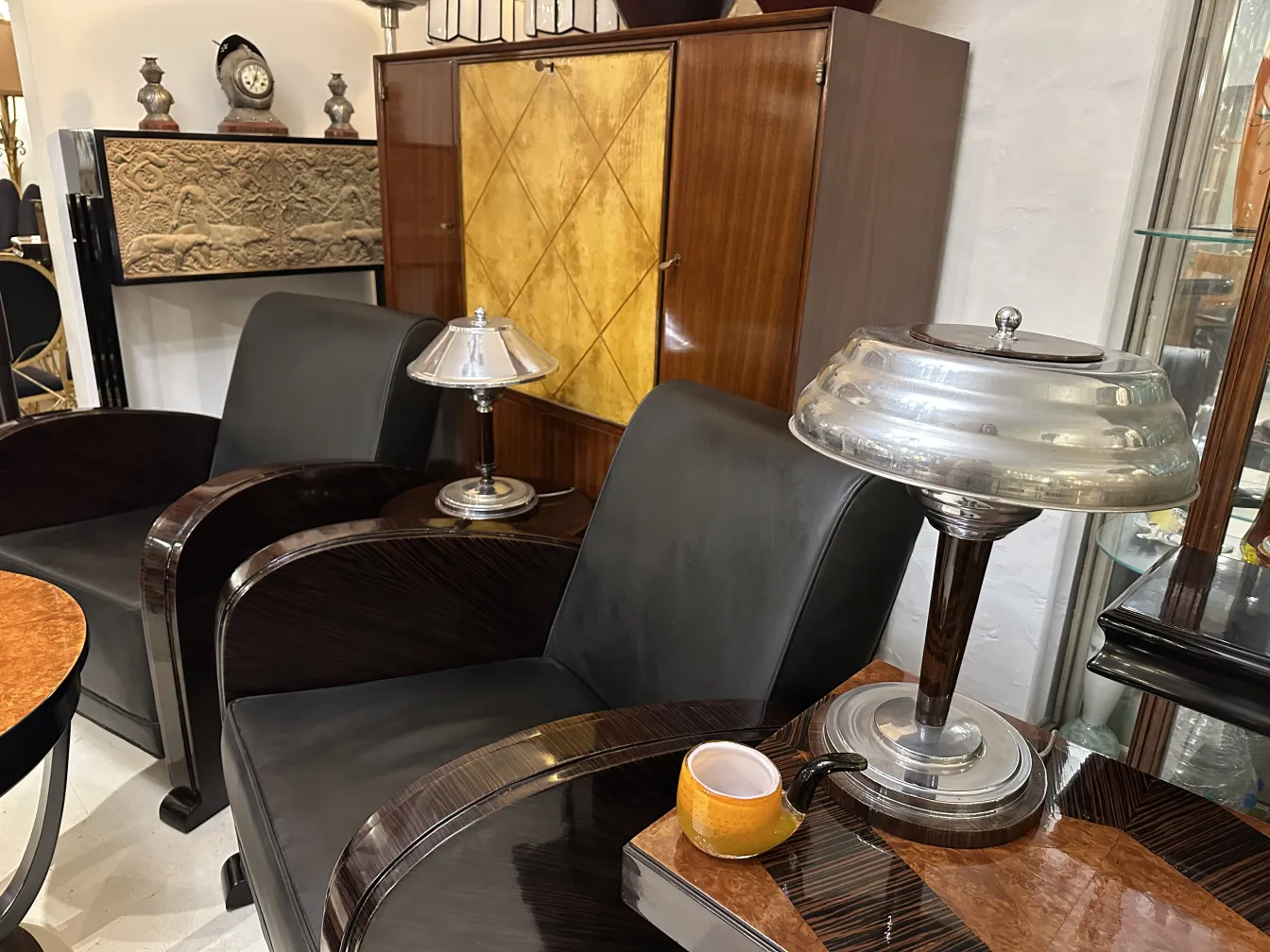 dos sillas elegantes, una lámpara y una taza en una mesa