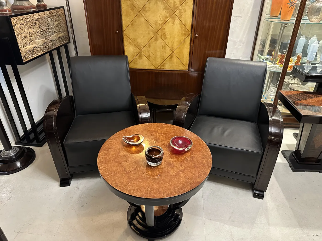 dos sillones negros junto a una mesa redonda con cristales coloridos