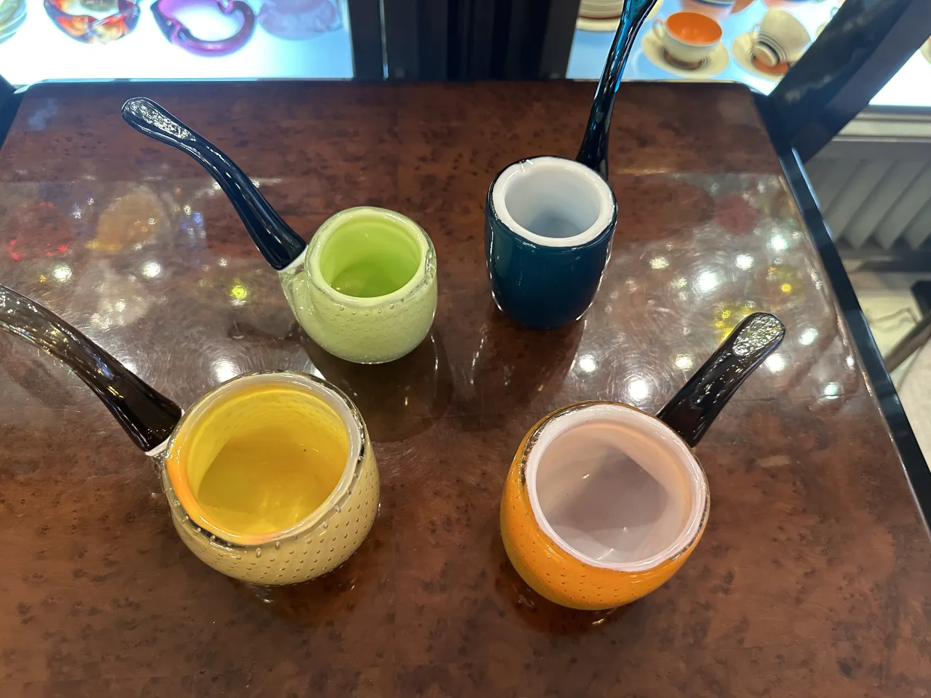 さまざまな色の古代のムラーノガラスのカップが装飾的なディテールで。