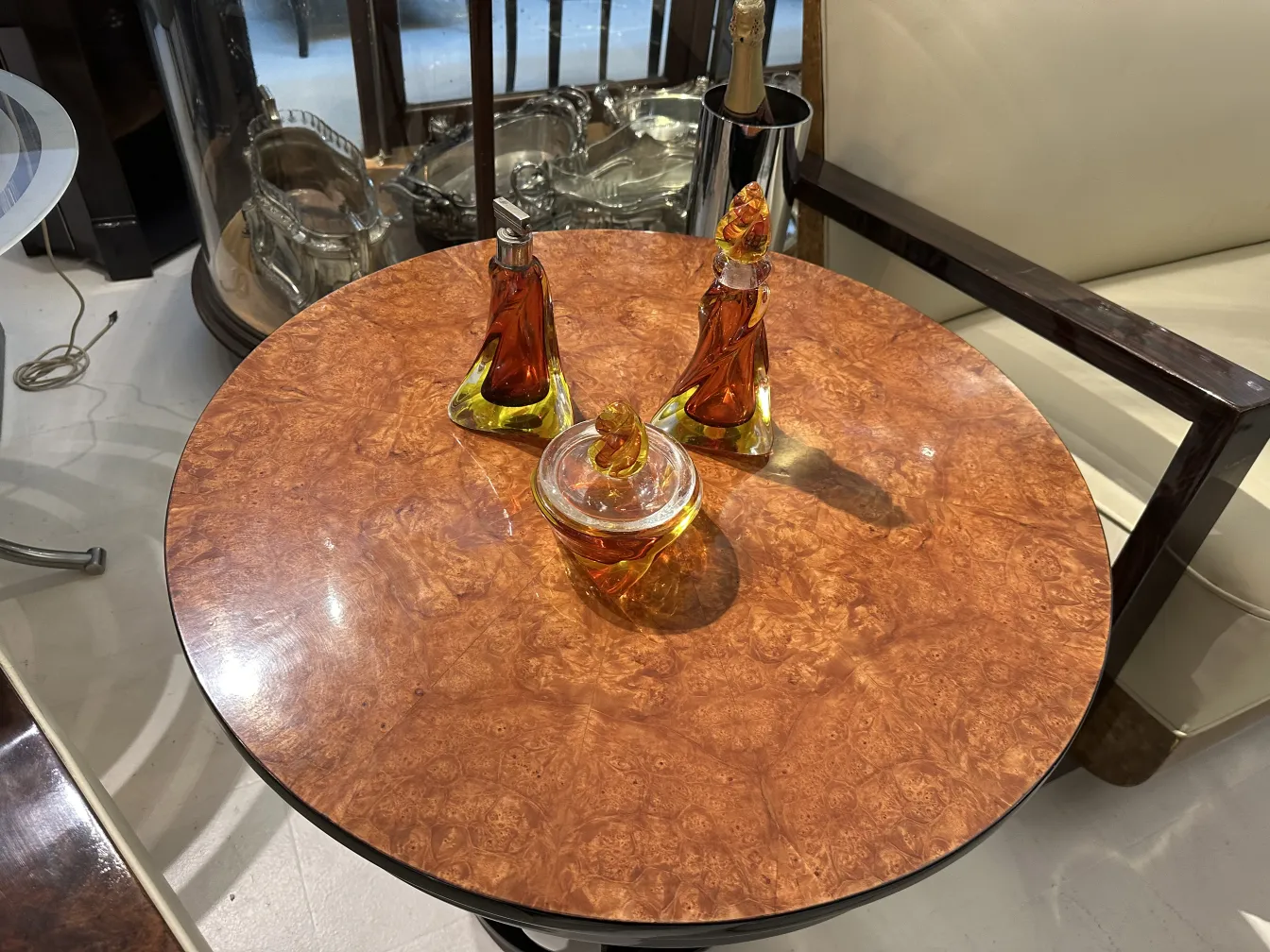 três garrafas de cristal de murano em uma mesa redonda