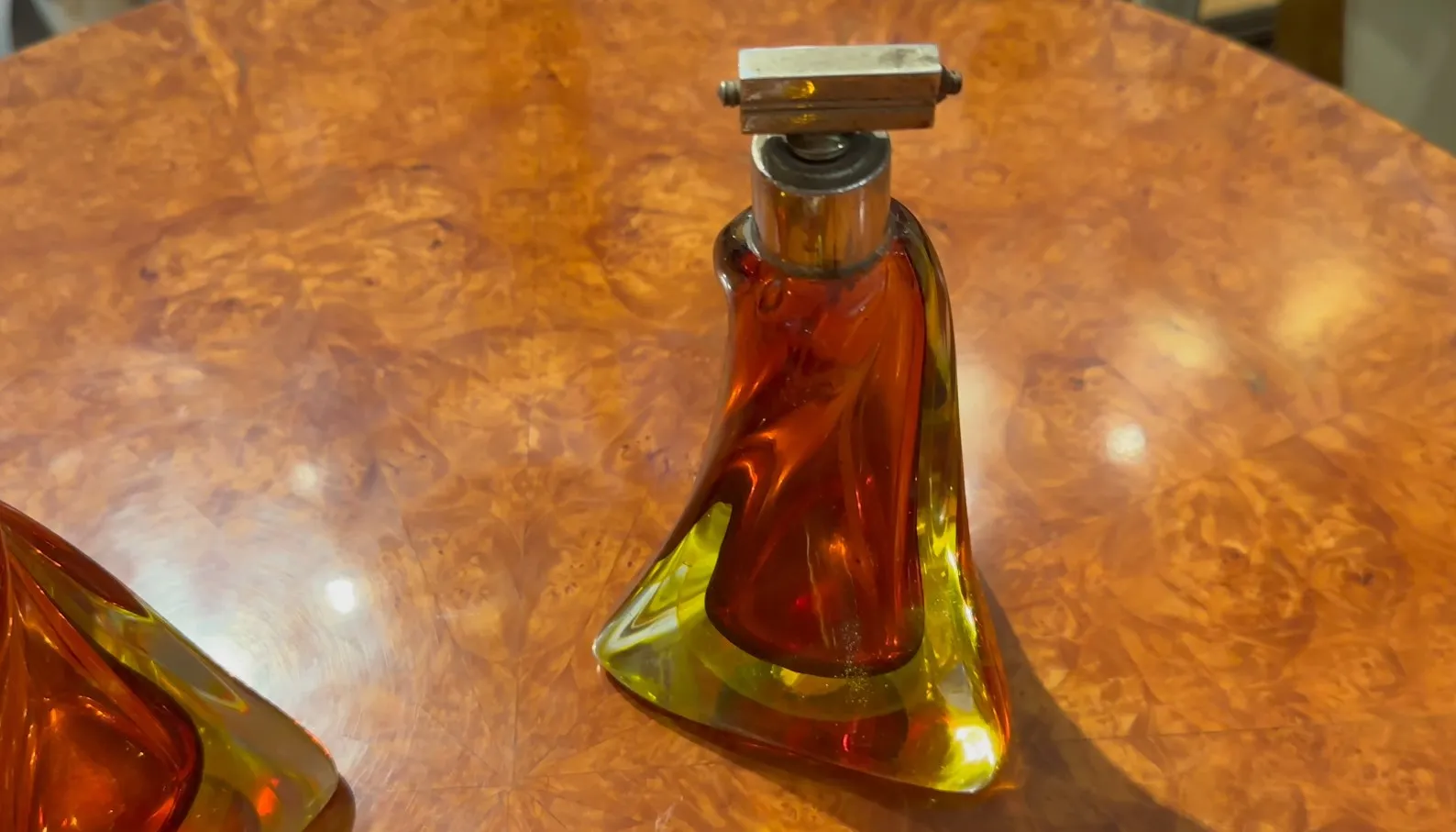 antike murano-glasflasche in bernstein und grünen tönen auf einem holztisch