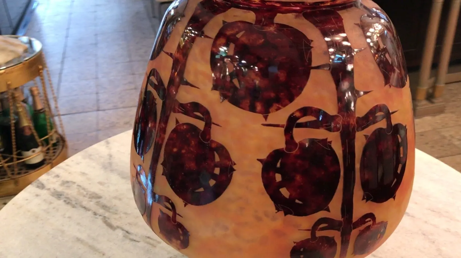 Vidrio firmado Le Verre con diseño de flores antiguas en fondo claro.