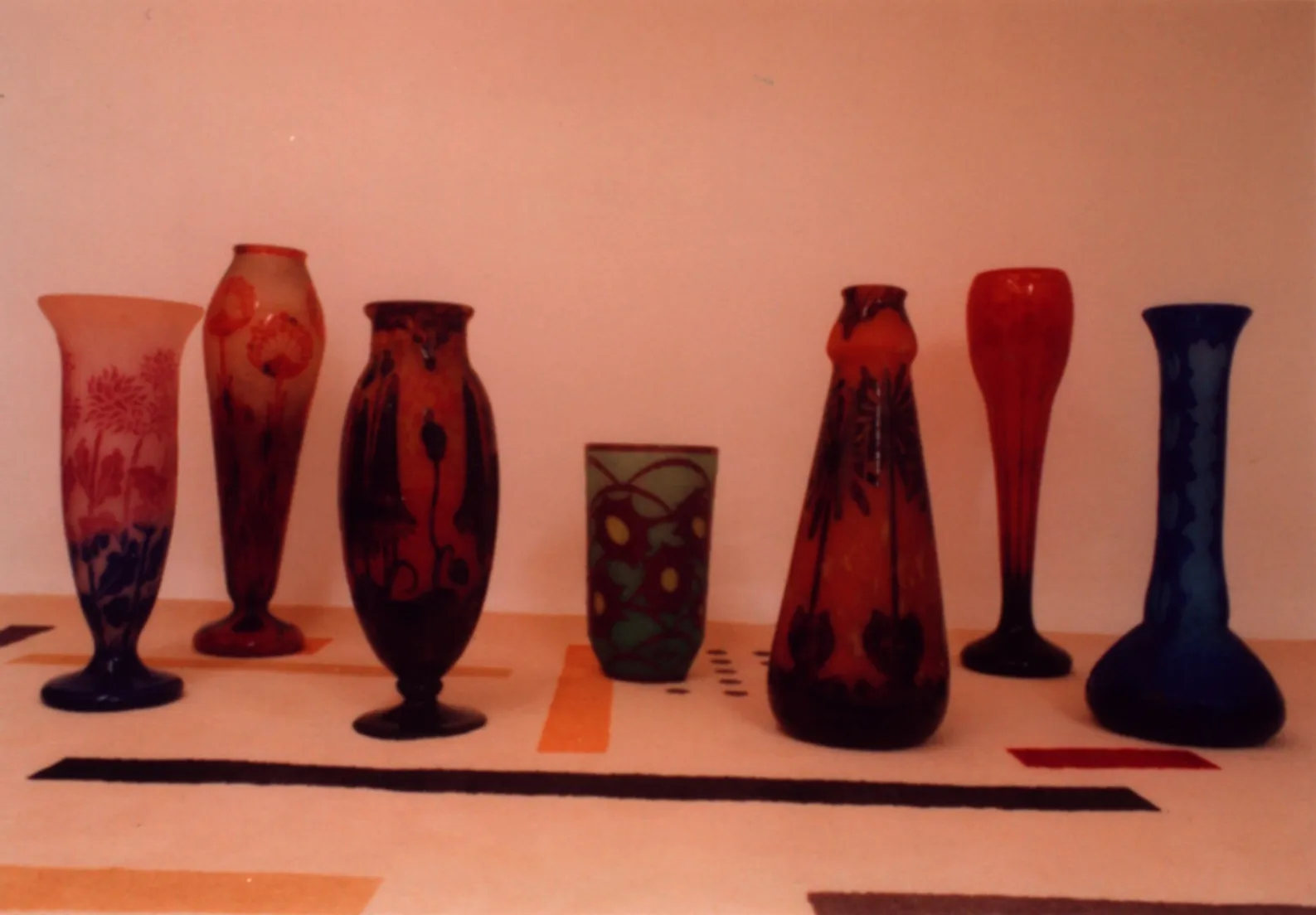 Vidro assinado Le Verre, exibição de antiguidades com vasos decorativos.