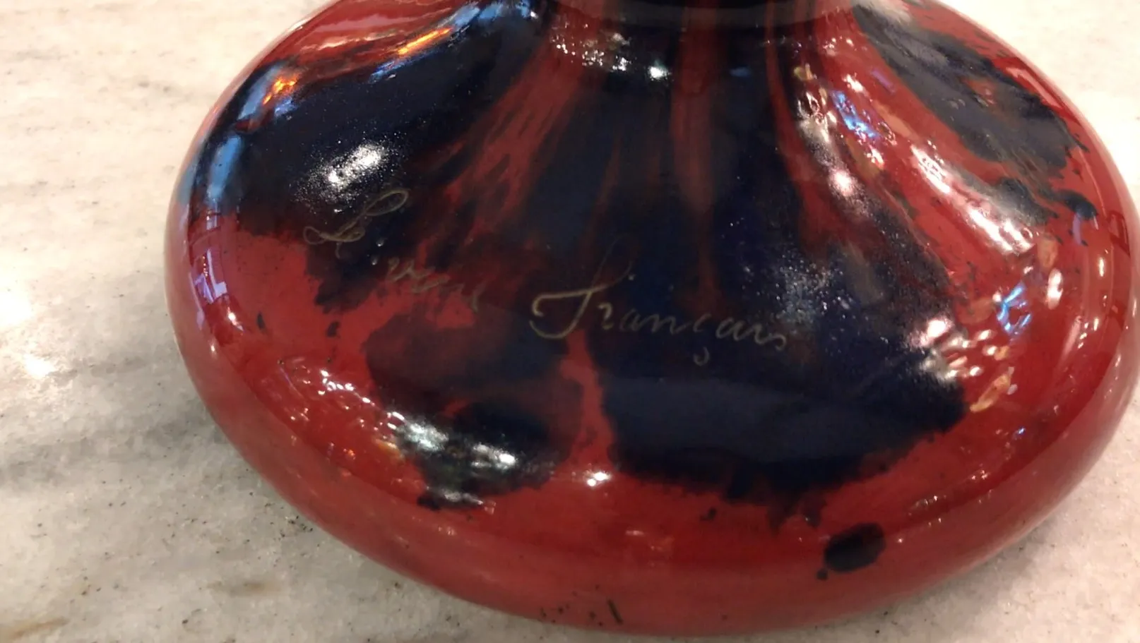 Vidrio antiguo con firma Le Verre en tonos rojos y negros.