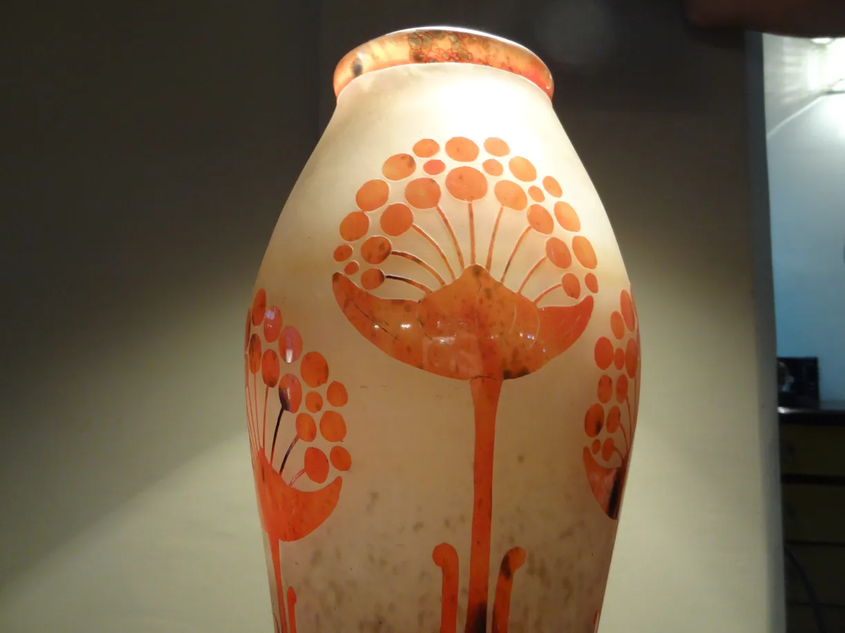 Vase en verre signé avec un design floral rouge.