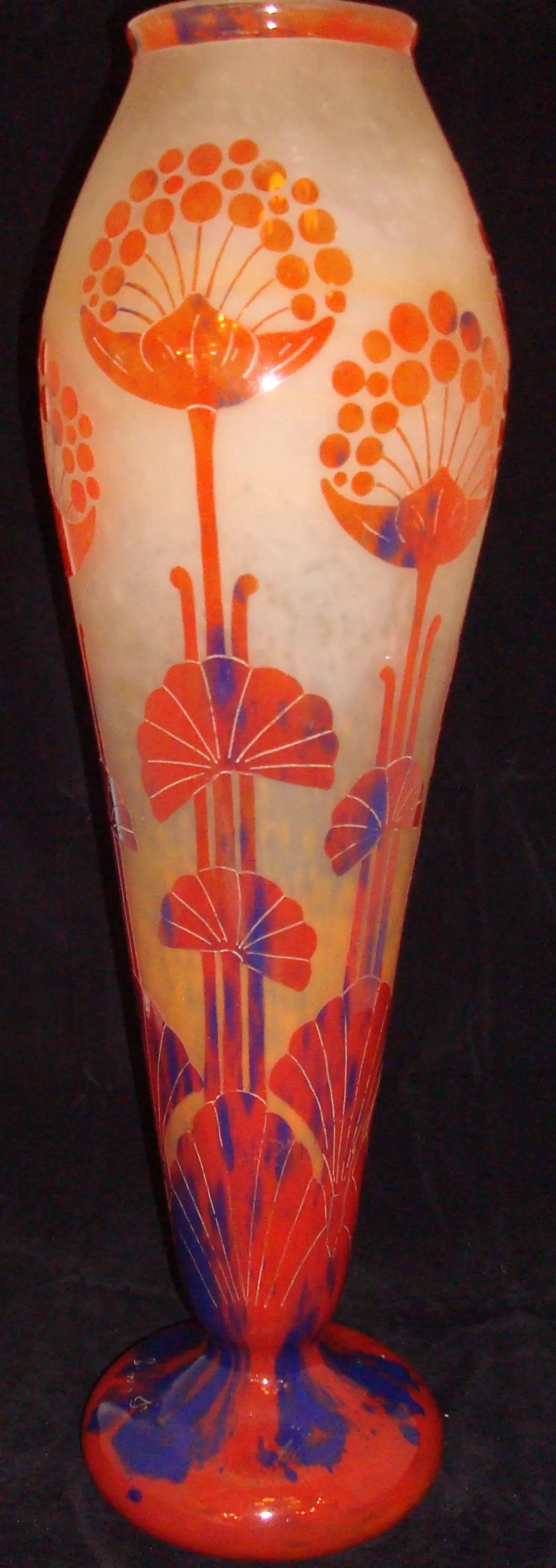 Antiquité verre signé Le Verre avec motif floral dans des tons d'orange et de bleu.