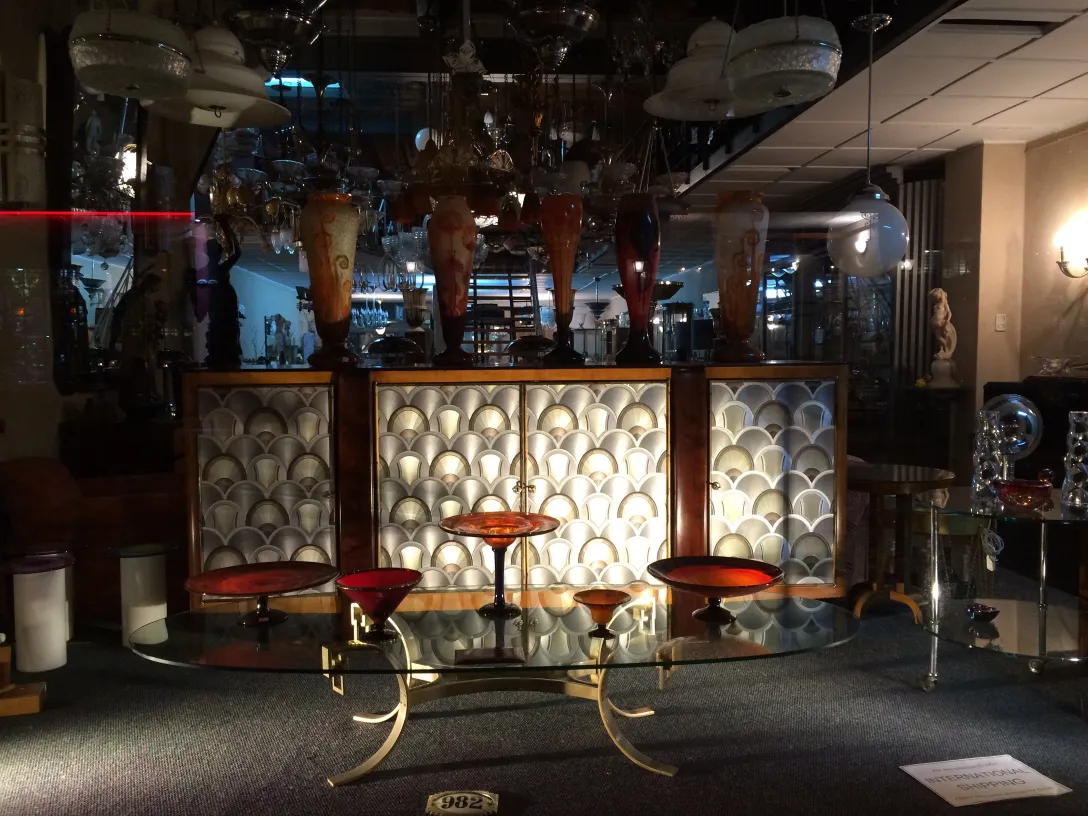 ग्लास पर हस्ताक्षरित Le Verre एक एंटीक स्टोर में प्रदर्शित किया गया, पृष्ठभूमि में रोशनी है।