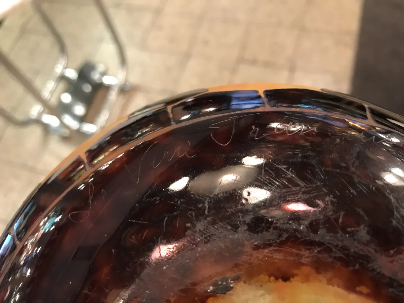 Vidrio antiguo firmado Le Verre, con detalles en su superficie. Fondo decorativo.