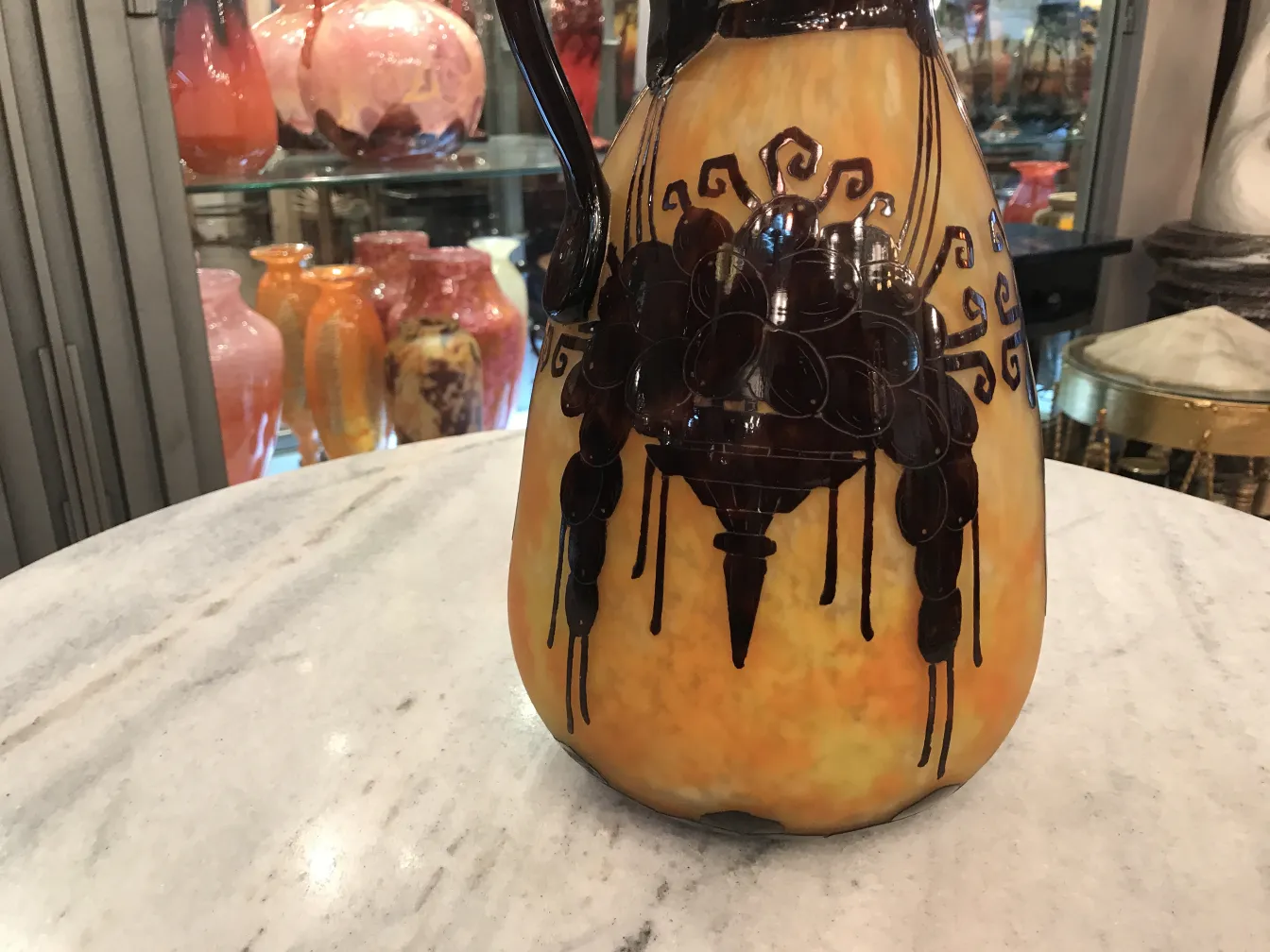 Vidrio firme de Le Verre con diseño en tonos cálidos y oscuro, fondo variado.