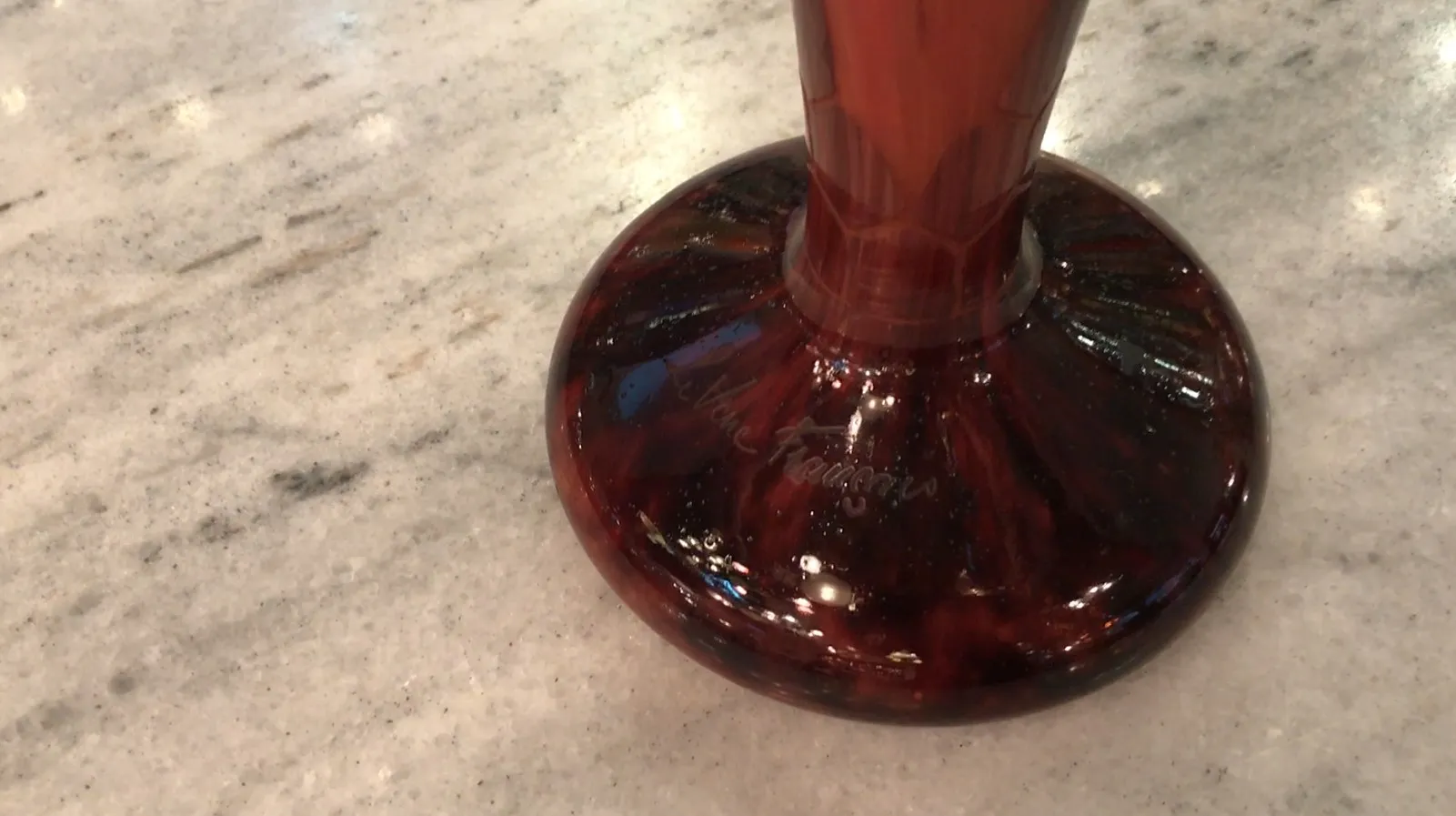 Antique signed glass Le Verre featuring a unique base design on marble surface.