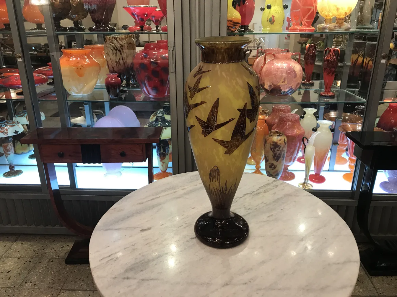 Antike Vase mit Signatur und gravierten Vögeln auf gelbem Hintergrund.