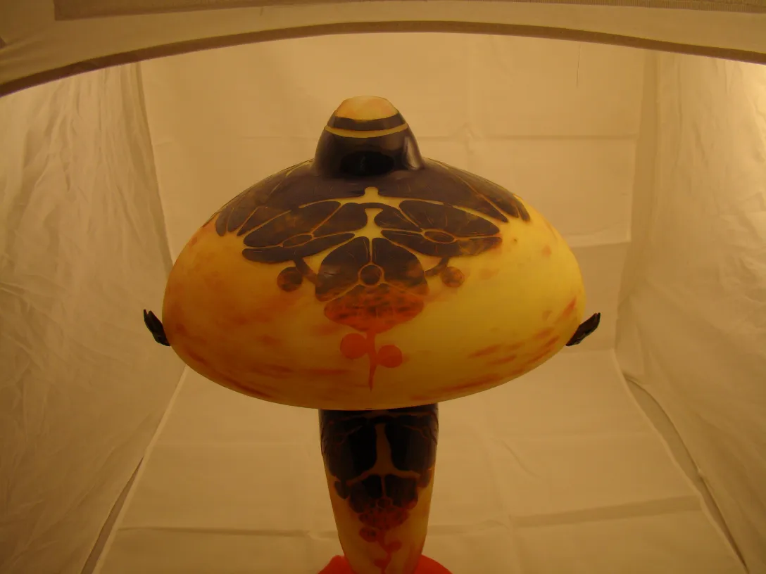 Vidrio antiguo firmado Le Verre con diseño floral, fondo claro.