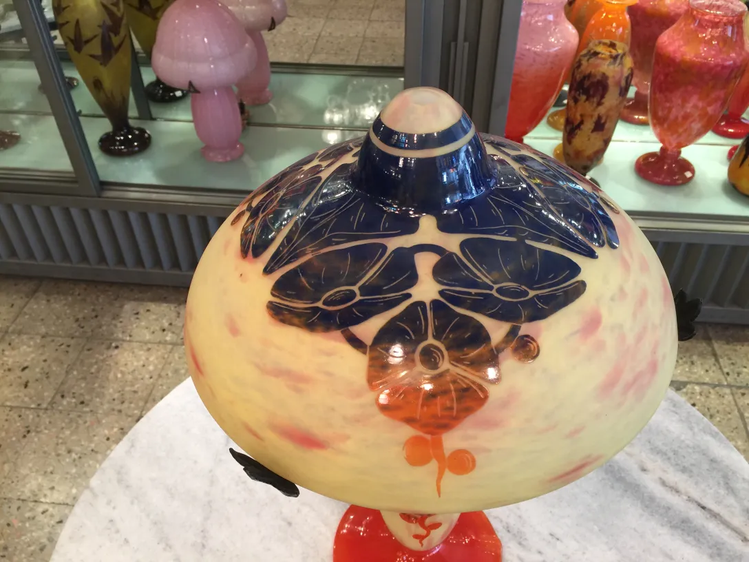 مصباح زجاجي قديم موقّع Le Verre مزين بنقوش زهرية بألوان صفراء وزرقاء.